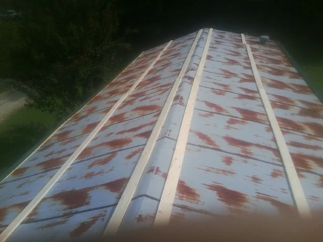Rusted metal roof panels with new wood purlins before replacement — Storm Damage Roof Repair in Graceville by Roofing Brothers